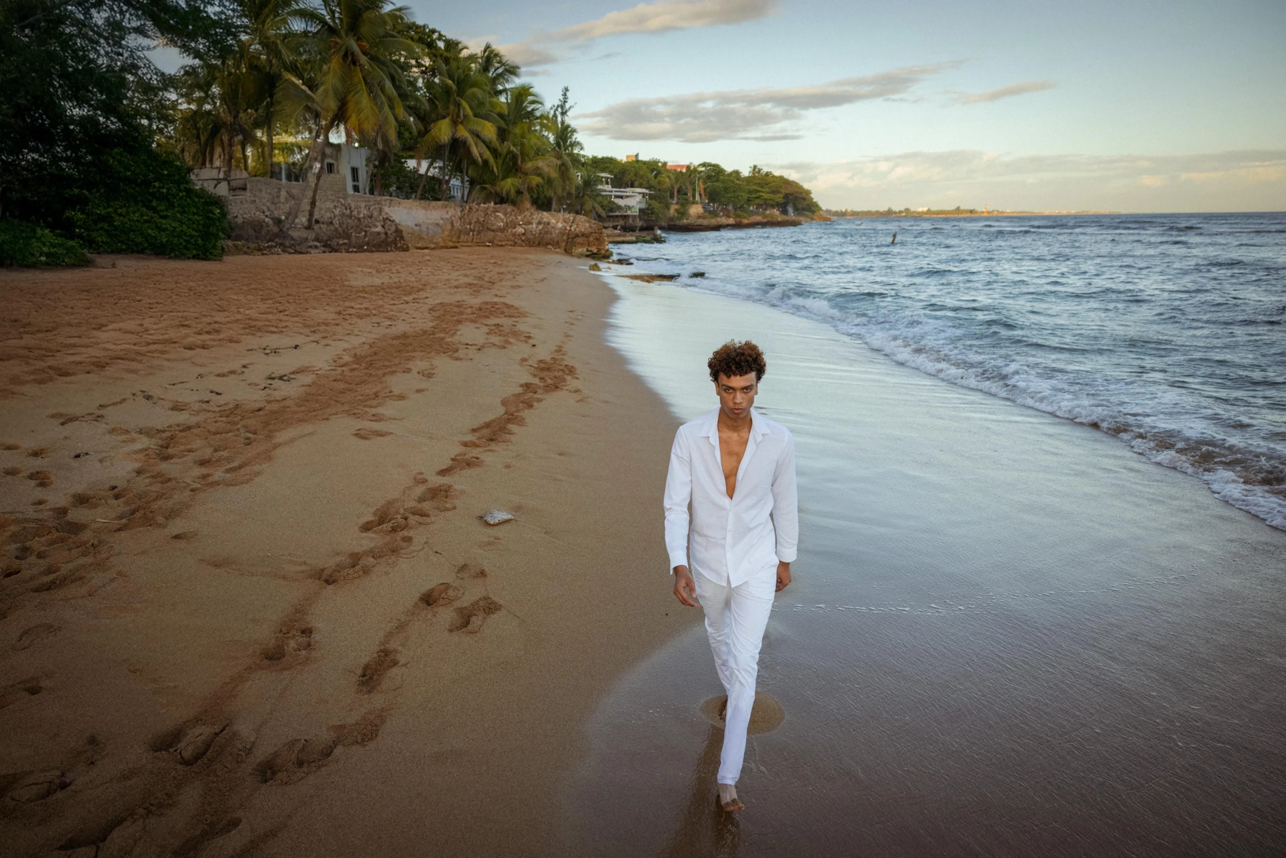 Fotografía de una persona caminando por la orilla de la playa de Santo Domingo.